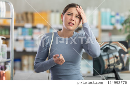 Young girl having headache in drugstore 124992776