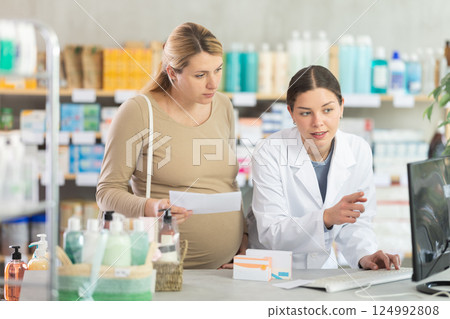 Pharmacist verifying prescribed medication for pregnant woman 124992808