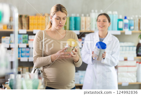 Pregnant woman choosing baby formula with help of pharmacist 124992836