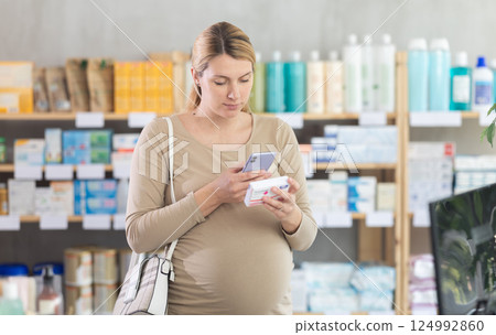 Pregnant woman scanning qr code of pills Pregnant woman scanning qr code of pills 124992860