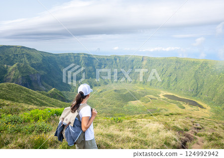 Hiker admires the Sete Cidades caldera view in Sao Miguel, Azores. Hiker admires the Sete Cidades caldera view in Sao Miguel, Azores. 124992942