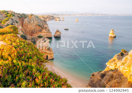 Scenic Algarve coastline: Cliffs, beach, and turquoise water attract tourists for relaxation 124992945