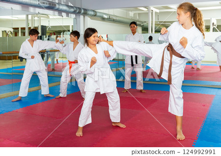 Girls and boys sparring during karate training Girls and boys sparring during karate training 124992991