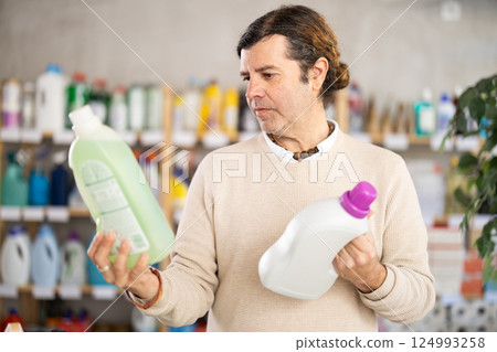 Man consumer with household chemical products for washing indoors Man consumer with household chemical products for washing indoors 124993258
