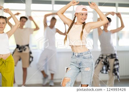 Group of girls an boys perform choreographic exercises and teaches energetic breakdancing waacking together 124993426