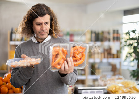 Man choose frozen shrimp for homemade lunch at supermarket 124993536