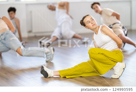 Group of young friends learn group dances - low break and breakdance in studio Group of young friends learn group dances - low break and breakdance in studio 124993595