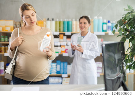 Pregnant woman choosing cream with help of pharmacist Pregnant woman choosing cream with help of pharmacist 124993603