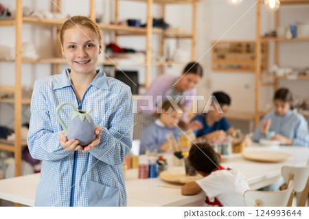 Teenage girl standing in art studio 124993644