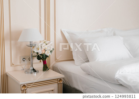 Elegant White Floral Bouquet on Nightstand with Lamp Elegant White Floral Bouquet on Nightstand with Lamp 124993811