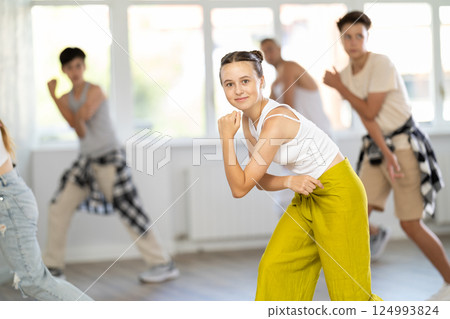 Group of girls an boys perform choreographic exercises and teaches energetic breakdancing waacking together Group of girls an boys perform choreographic exercises and teaches energetic breakdancing waacking together 124993824