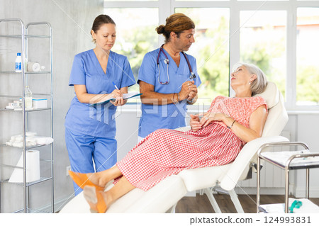 Female nurse and male doctor carries out survey of mature female patient about allergic reactions 124993831