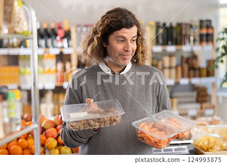 Man choose shrimp and shellfish Bolinus brandaris together for homemade lunch at supermarket Man choose shrimp and shellfish Bolinus brandaris together for homemade lunch at supermarket 124993875