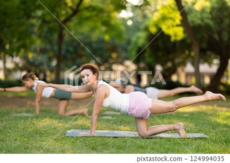 Adult woman doing yoga in park Adult woman doing yoga in park 124994035