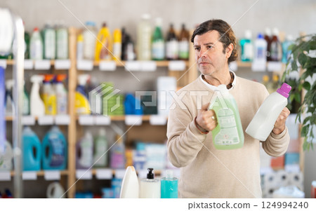 Man consumer with household chemical products for washing indoors 124994240
