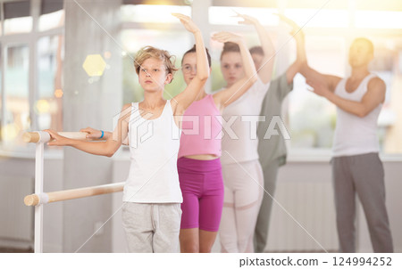 Teenage boy practicing ballet positions in dance studio 124994252