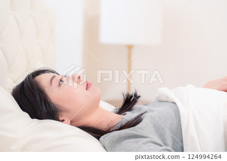 Young woman sleeping in bed 124994264