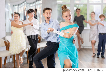 Teen boy and girl are dancing contemporary modern discofox in couple during lesson at studio 124994612