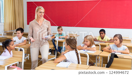 Woman teacher talking with pupils at classroom Woman teacher talking with pupils at classroom 124994672