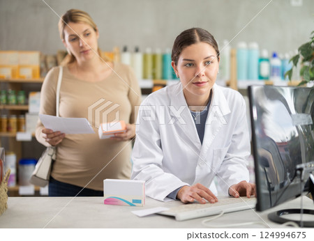 Pharmacist checking supplements safety for expecting woman with prescription Pharmacist checking supplements safety for expecting woman with prescription 124994675