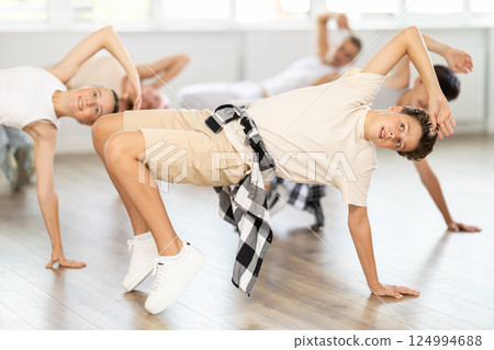Teen boy dancing breakdancing in group Teen boy dancing breakdancing in group 124994688