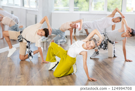 Teenage girl practicing hip-hop floor-works in training hall 124994708