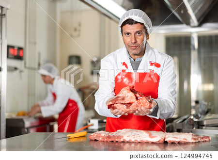 Confident man seller demonstration quality porks in butcher shop Confident man seller demonstration quality porks in butcher shop 124994745