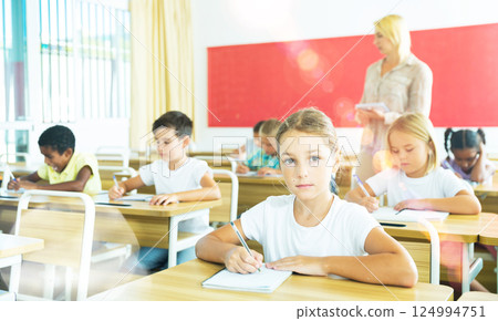 School girl working at lesson in classroom School girl working at lesson in classroom 124994751