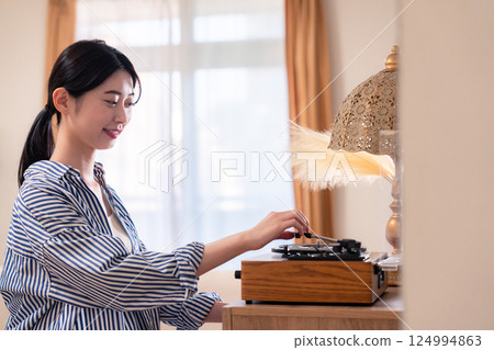 Young woman listening to records at home 124994863