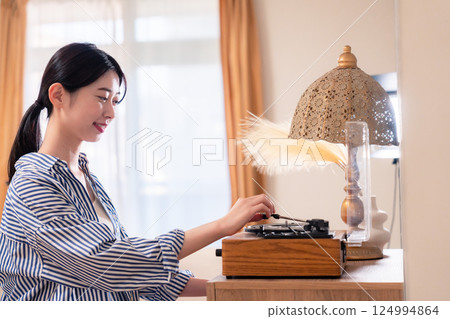 Young woman listening to records at home 124994864