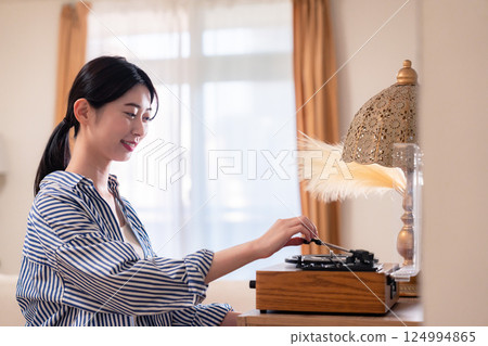 Young woman listening to records at home 124994865