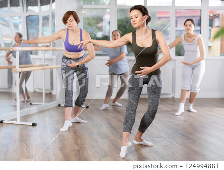 Woman participating in beginners ballet class in choreography studio 124994881