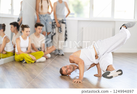 Dance teacher shows how to dance low breaking in studio 124994897
