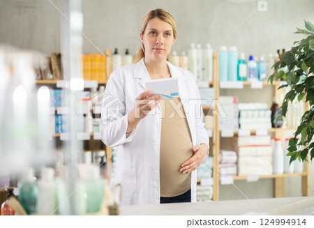 Pregnant pharmacist offering preparation in box Pregnant pharmacist offering preparation in box 124994914