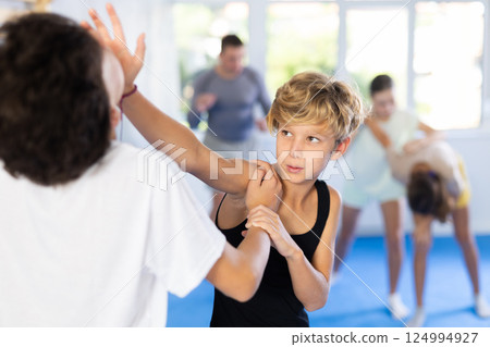 Boy and girl train to perform works out blow to jaw at opponent, while learning self-defense Boy and girl train to perform works out blow to jaw at opponent, while learning self-defense 124994927