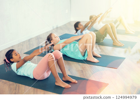 Girl perform exercises to strengthen muscles of trunk, body. Abs training without pain Girl perform exercises to strengthen muscles of trunk, body. Abs training without pain 124994979