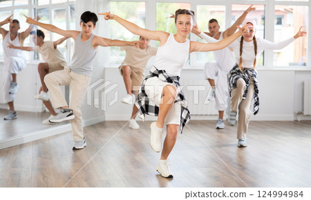 Teenage girl practicing hip hop reject step in training hall 124994984
