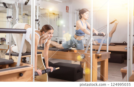 Young girl doing exercises on wunda chair in pilates studio 124995035