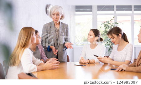 Senior woman team leader stands and leads staff meeting.Group work, teamwork 124995097
