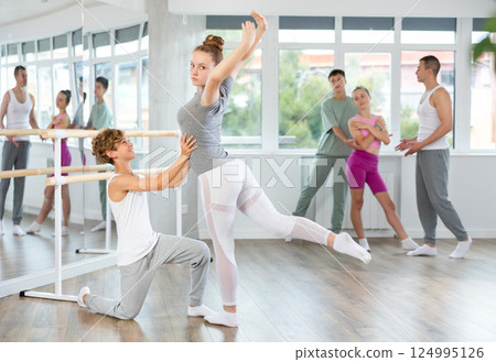 Boy and girl in pair train to perform ballet dance during rehearsal in studio 124995126