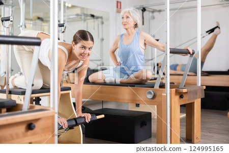 Woman pilates stretching sport in reformer bed Woman pilates stretching sport in reformer bed 124995165