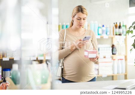 Pregnant woman scanning qr code of pills 124995226