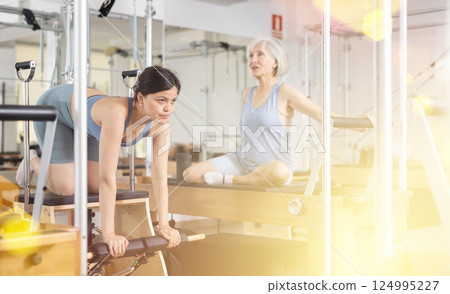 Young asian girl exercising on wunda chair in pilates studio 124995227