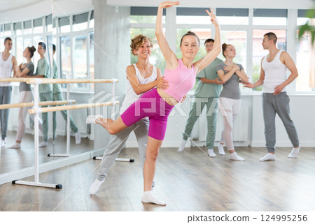 Teenage girl and boy practicing arabesque position of ballet in dance studio 124995256