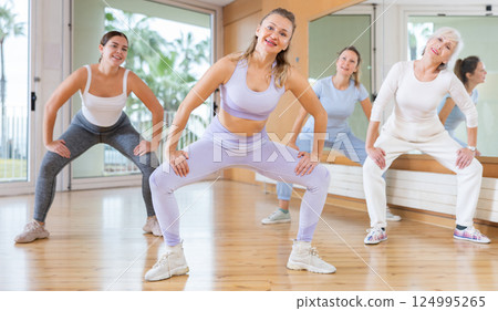 Active middle-aged woman practicing aerobic dance in training hall 124995265