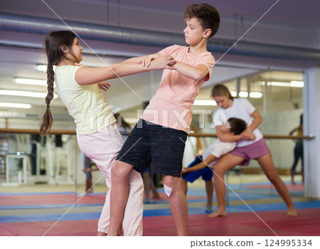 Kids learning self-defence moves in gym 124995334