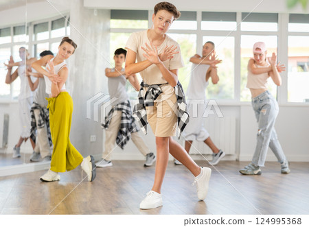 Teenage boy practicing basic hip hop moves in training hall 124995368