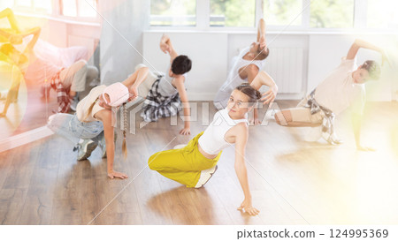 Teenage girl practicing hip-hop floor-works in training hall 124995369