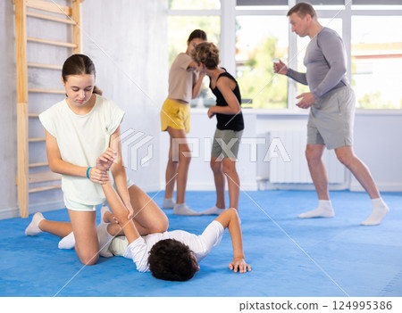 Girls and boys adolescents of performing protection with wring hands during training in self-defense 124995386