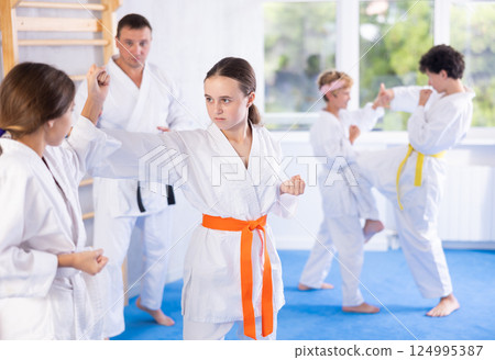 Young pupils train to perform defensive karate installations and attacking combat techniques Young pupils train to perform defensive karate installations and attacking combat techniques 124995387